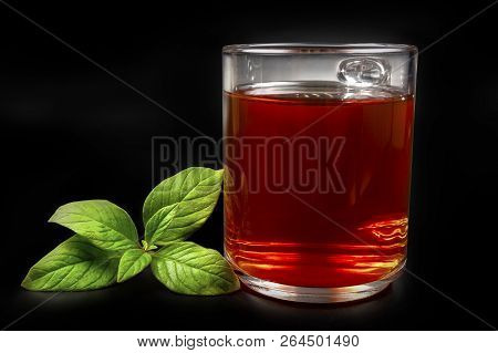 A Mug Of Tea On A Black Background, And Next Is A Green Mito
