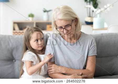 Cute Granddaughter Hug Sad Grandmother Comforting Her At Home