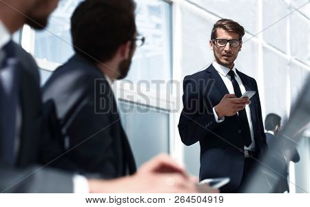 businessman with a smartphone standing in his ofiice