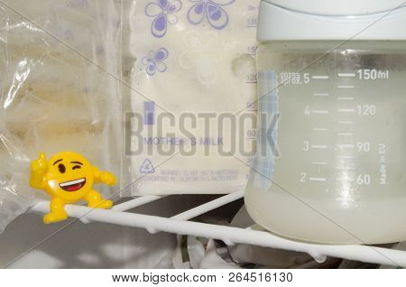 Lot Of Frozzen Breast Milk In Storage Bags Stored In The Freezer And Baby Bottle With Fresh Expresed