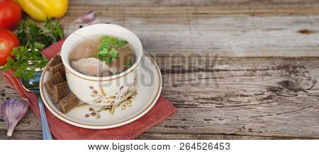 Clear Beef Broth, Bouillon In White Bowl And Vegetables On Wooden Table.