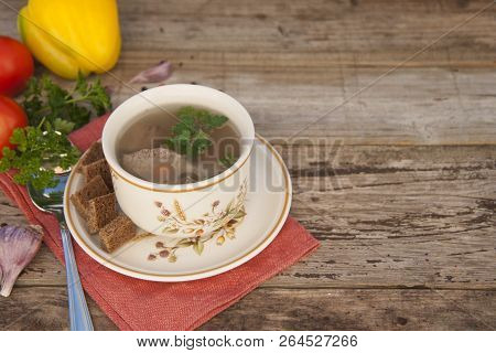 Clear Beef Broth, Bouillon In White Bowl And Vegetables On Wooden Table. Copy Space.