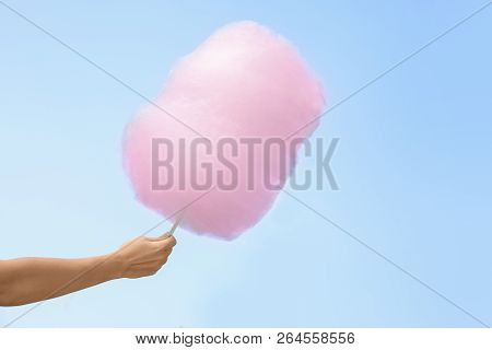 Woman Holding Cotton Candy Against Blue Sky