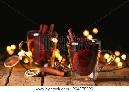 Mulled Wine With Cinnamon And Orange On Wooden Table. Space For Text
