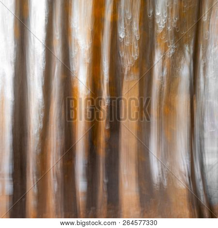 Blurred Tree Trunks At A City Park With Golden Autumn Leaves. Intentional Camera Movement Icm. Fall 