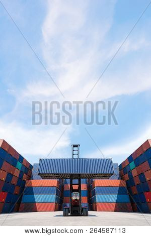 Forklift Truck Lifting Cargo Container In Shipping Yard Or Dock Yard With Cargo Container Stack In B