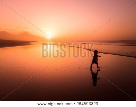 Silhouette of little boy running on Cofete beach in Fuerteventura, Canary Islands.
