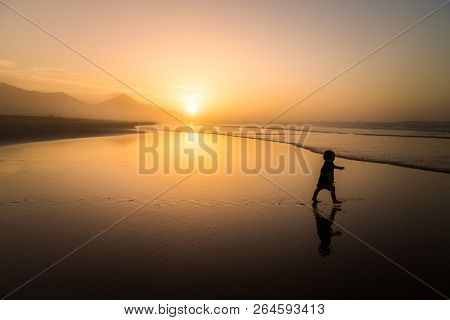 Silhouette of little boy running on Cofete beach in Fuerteventura, Canary Islands.
