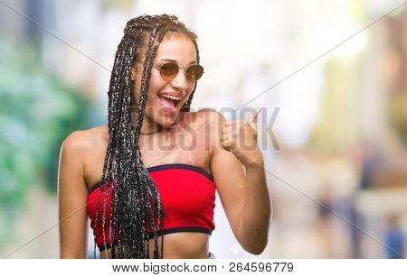 Young braided hair african american with birth mark wearing sunglasses over isolated background doing happy thumbs up gesture with hand. Approving expression looking at the camera with showing success