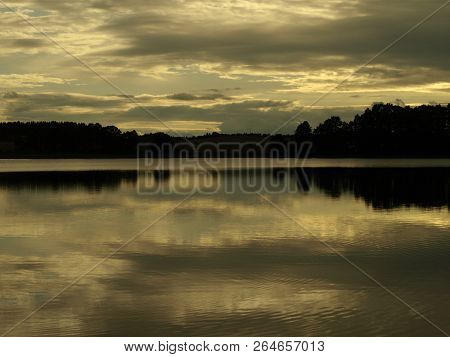 Yellow Sunset Over The Lake And Clouds