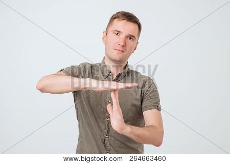 Handsome Young Serious Man, Coach Showing Time Out Gesture With Hands, Isolated On White Background.