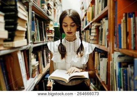 Girl With Pigtails In White Blouse At Old Library.