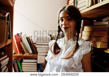 Girl With Pigtails In White Blouse At Old Library.