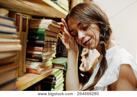 Girl With Pigtails In White Blouse At Old Library.