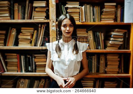 Girl With Pigtails In White Blouse At Old Library.