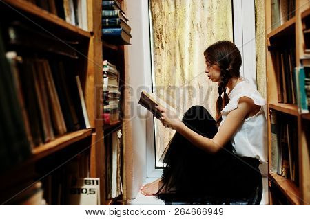 Girl With Pigtails In White Blouse At Old Library.