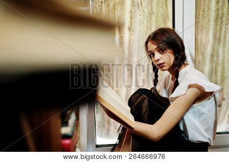 Girl With Pigtails In White Blouse At Old Library.