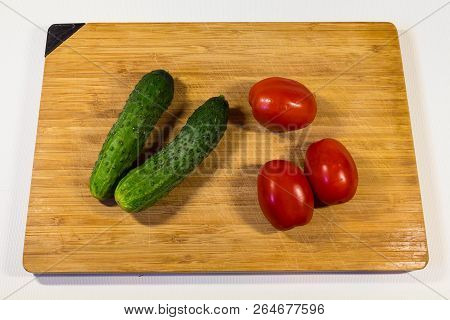 Vegetables Cucumbers Tomatoes On A Wooden Board