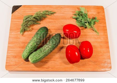 Vegetables Cucumbers Tomatoes On A Wooden Board