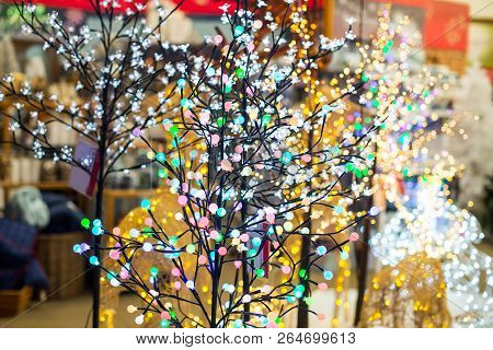 Various Colorful Glowing Christmas Lights In The Shape Of Trees In The Shop. Holiday Background. Gar