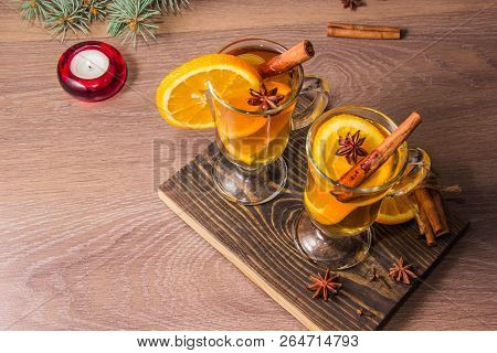 Two Glasses With Delicious Fragrant Tea Of Mulled Wine With Orange And Spices On A Wooden Board With