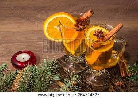 Two Glasses With Delicious Fragrant Tea Of Mulled Wine With Orange And Spices On A Wooden Board With