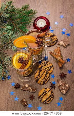 Two Glasses With Delicious Fragrant Tea Of Mulled Wine With Orange And Spices On A Wooden Board With