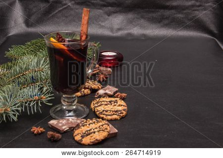 A Glass Of Flavored Mulled Wine On A Black Leather Background With Biscuits Pieces Of Chocolate Chop