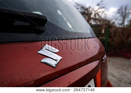 Senov, Czech Republic - Octobe 23, 2018: Logo Of Suzuki Automotive Company On A Dark Red Small Suv S