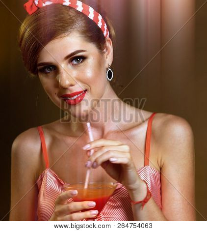 Martini glass flirt. Fun and flirty drinks through straw. Pin up girl drink represent martini Mary cocktail. Tone image sepia and sun flare on gradation background.