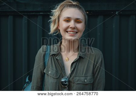 Urban People Concept. Carefree Young Woman Portrait Smiling, Dressed In A Khaki Romper With A Backpa