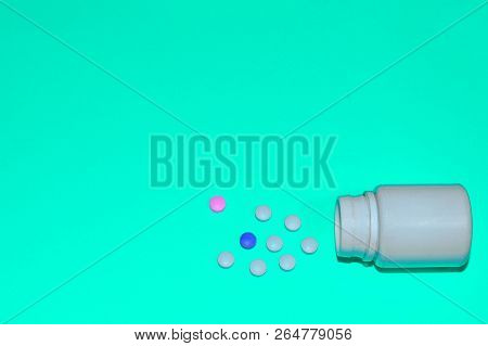Assorted Pharmaceutical Medicine Pills, Tablets And Capsules And Bottle On Blue Background. Space Fo