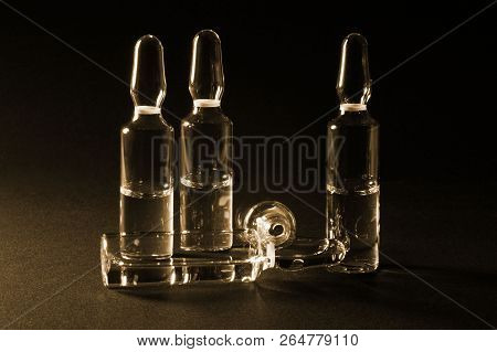 Row Of Ampulas With Medicine On Dark Sepia Background