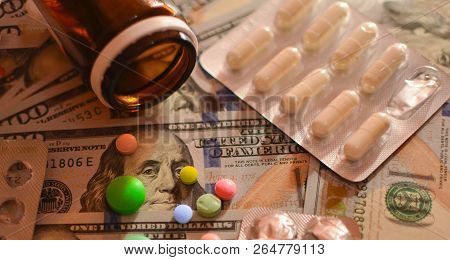 Assorted Pharmaceutical Medicine Pills, Tablets And Capsules On Wooden Spoon. Green Background
