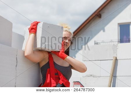 Strong Pretty Woman Working On Construction Site, Building House, Installing Gray Airbricks. Industr