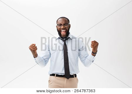 Happy African Businessman Wearing A Corporate Grey Shirt And Black Tie Punching The Air With His Fis