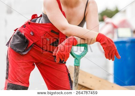 Unrecognizable Attractve Woman Wearing Worker Dungarees Working On Constructive Site Having Big Shov