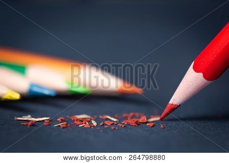 Red Sharp Pencil With Pieces Of Graphite On A Blue Textured Paper. The Concept Of Idea Creativity, E