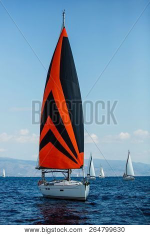 Sailing yacht under colorful bright gennaker participates in the regatta along the Greek coast, the Aegean sea.