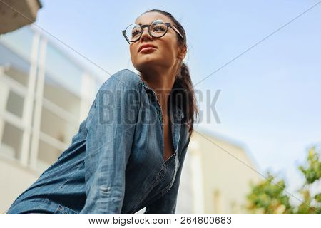 Close Up Of Young Attractive Bespectacled Woman Looking Aside.