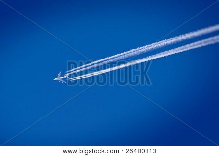 Volo aereo sul cielo azzurro lasciando le linee bianche