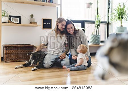 Beautiful Little Girl And Her Parent Getting Some Puppy Love On The Living Room