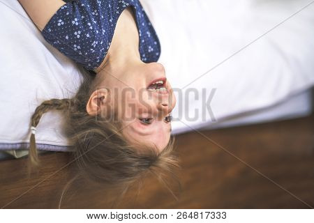Little Beautiful Girl On Bedroom Upside Down