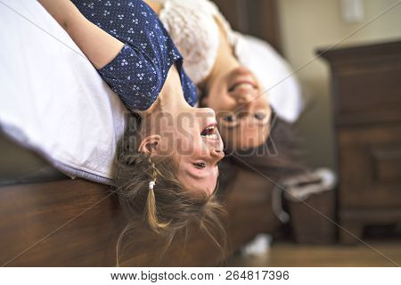 Mother Playing With Her Baby In The Bedroom Upside Down