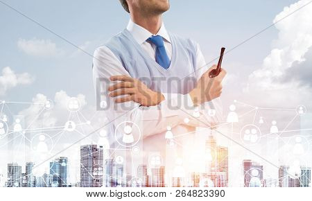 Double Exposure Of Confident And Young Businessman In Smart-casual Wear Smoking Pipe And Modern City