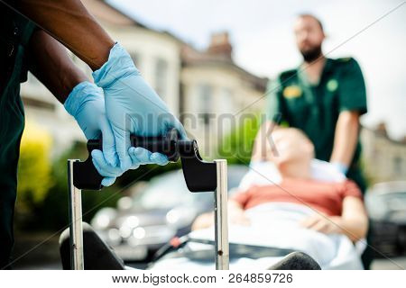 Paramedics moving a patient on a stretcher to an ambulance