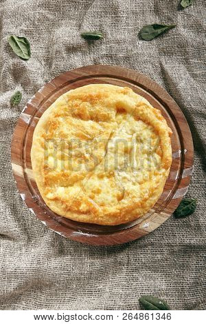 Megrelian Khachapuri Made From a Delicious Tender Dough with Melted Burnt Imeretian Cheese and Butter Top View. Traditional Most Common Circular Hachapuri Topped with Lots of Grated Cheeses