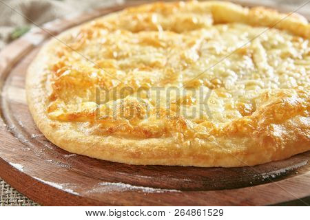 Megrelian Khachapuri Made From a Delicious Tender Dough with Melted Burnt Imeretian Cheese and Butter Close Up. Traditional Most Common Circular Hachapuri Topped with Lots of Grated Cheeses