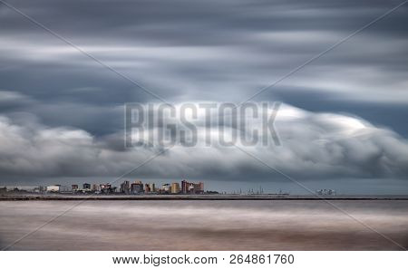 Ultra Long Exposure Of Skyscrappers Near Sea With Clouds