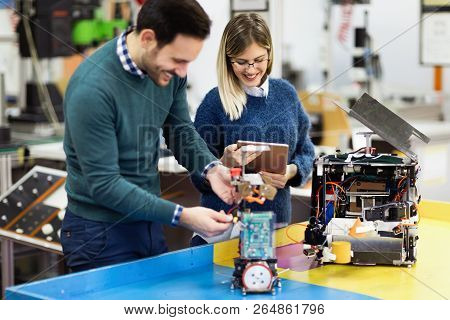 Young Attractive Students Of Mechatronics Working On Project